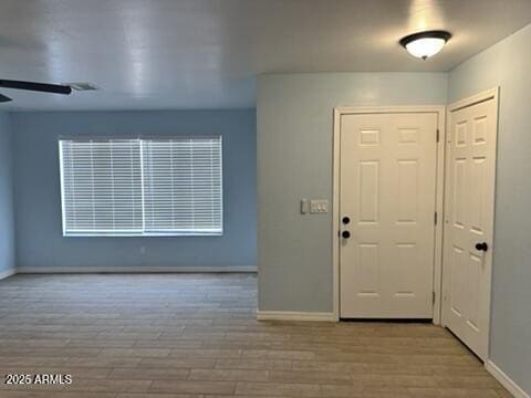 foyer with ceiling fan and light wood-type flooring