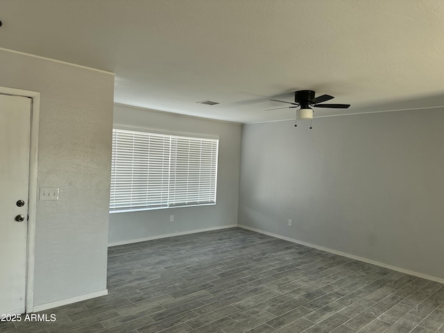 empty room featuring dark wood-type flooring and ceiling fan