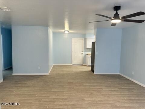 empty room featuring ceiling fan and light wood-type flooring