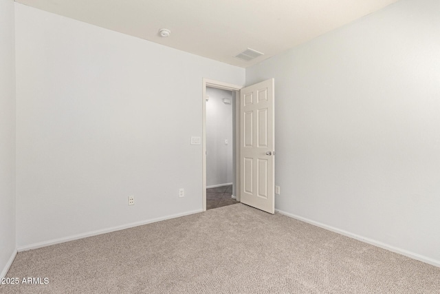 unfurnished room with light colored carpet, visible vents, and baseboards