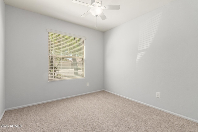 carpeted spare room with baseboards and a ceiling fan