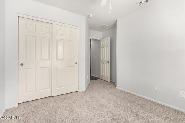 unfurnished bedroom featuring a closet, visible vents, baseboards, a ceiling fan, and carpet floors