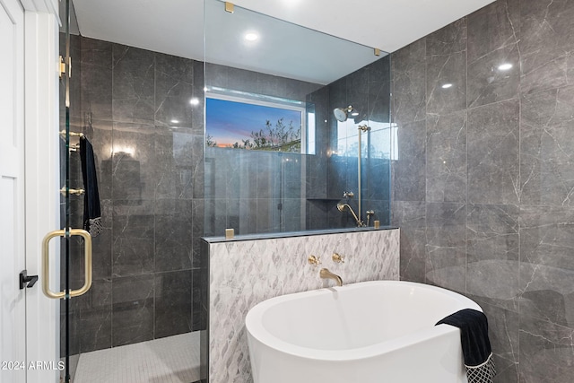 bathroom with separate shower and tub and tile walls