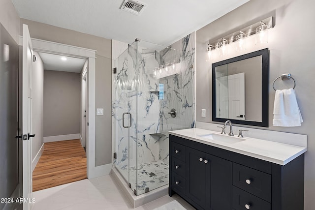 bathroom with vanity, an enclosed shower, and hardwood / wood-style flooring