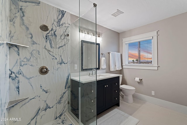 bathroom featuring vanity, tile patterned floors, toilet, and tiled shower