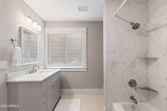 bathroom with tiled shower / bath combo, tile patterned floors, and vanity