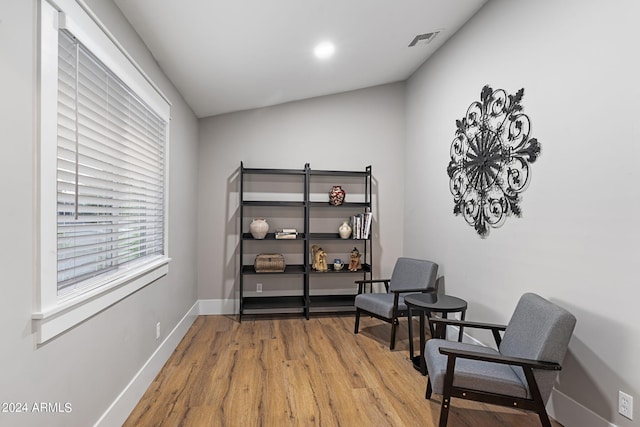 living area with light wood-type flooring and vaulted ceiling