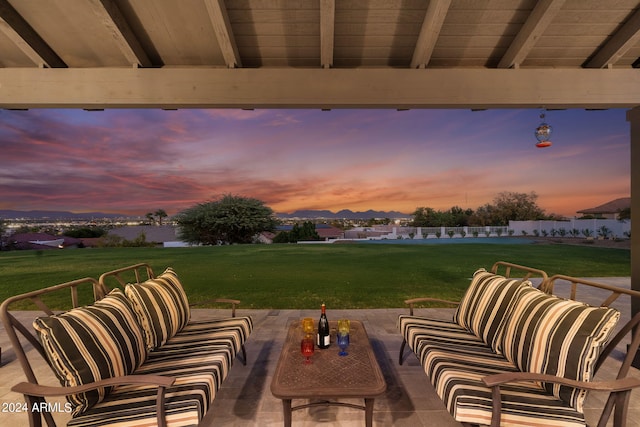 patio terrace at dusk featuring an outdoor hangout area and a yard