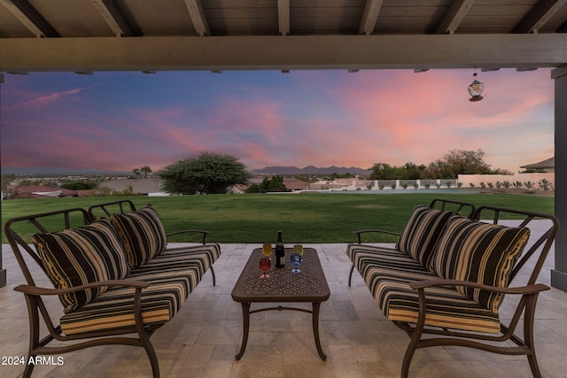 patio terrace at dusk with an outdoor living space and a yard