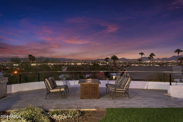 patio terrace at dusk featuring a fire pit and a mountain view