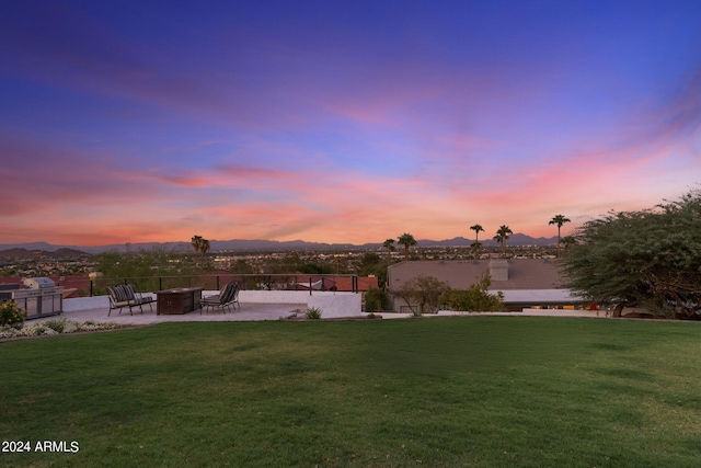 yard at dusk with a mountain view and a patio area