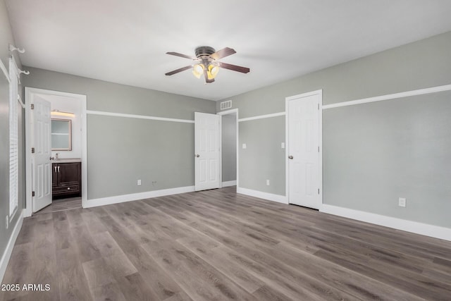 17201 N 35th Dr, Glendale, AZ 85308 - unfurnished bedroom featuring baseboards, wood finished floors, ensuite bath, and ceiling fan