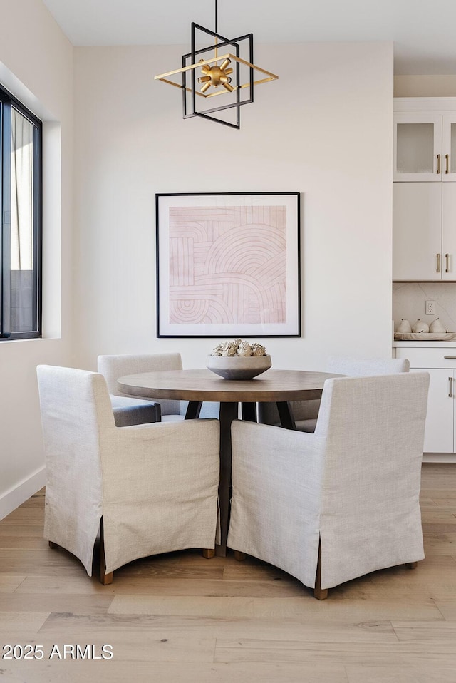 dining area with a chandelier and light hardwood / wood-style flooring