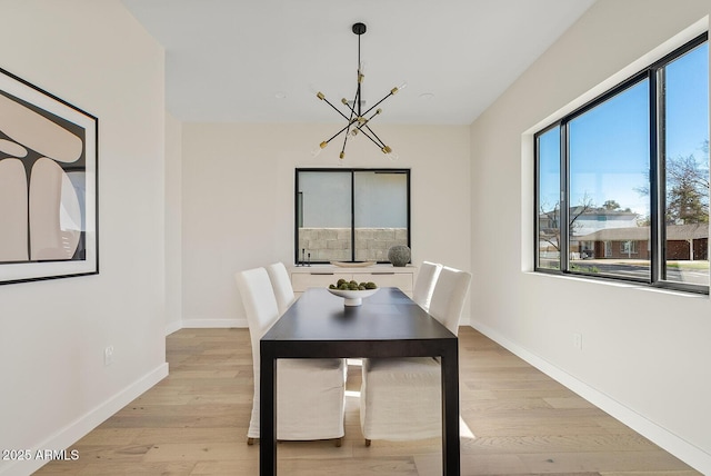 unfurnished dining area with an inviting chandelier and light wood-type flooring