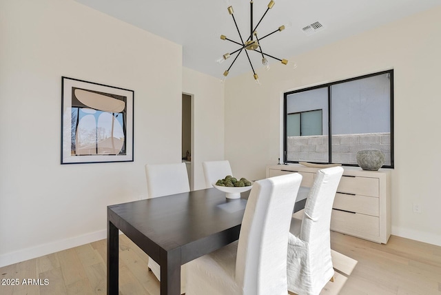 dining area with an inviting chandelier and light wood-type flooring