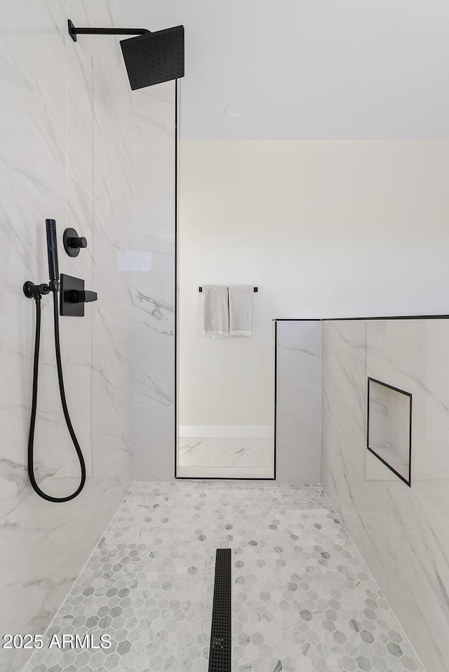 bathroom with a tile shower and tile patterned floors