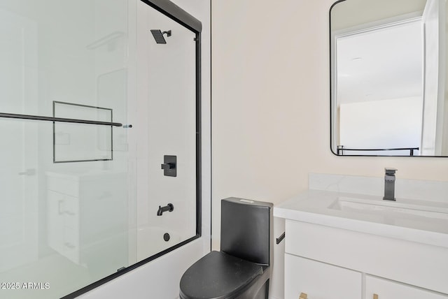 full bathroom featuring toilet, vanity, and shower / bath combination with glass door