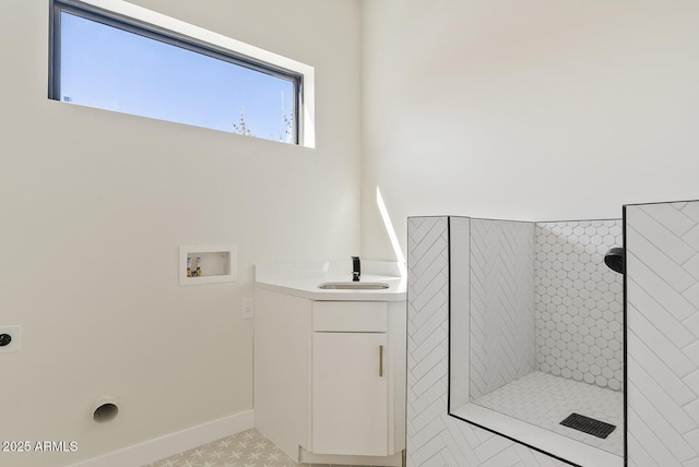 bathroom with vanity and a tile shower