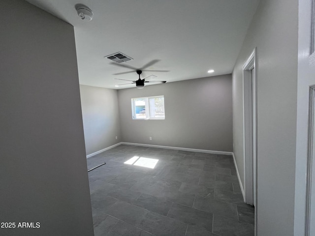 empty room featuring baseboards, visible vents, and ceiling fan