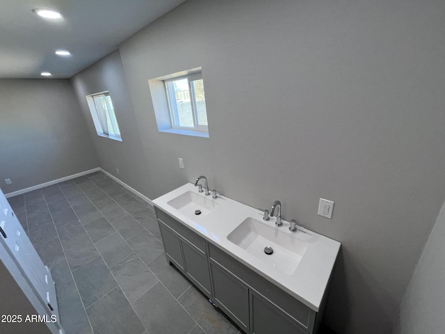 full bathroom featuring double vanity, recessed lighting, a sink, and baseboards