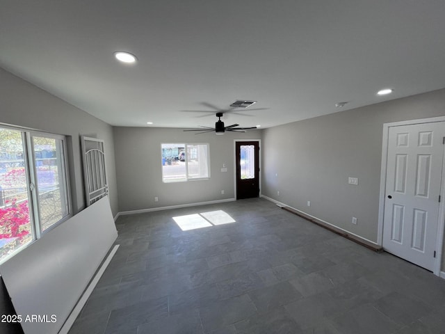 unfurnished room with a wealth of natural light, visible vents, and baseboards