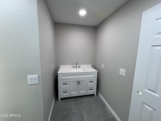 bathroom with vanity, baseboards, and tile patterned floors