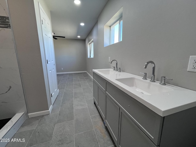 bathroom with double vanity, recessed lighting, a sink, and baseboards