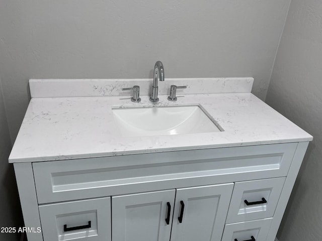 bathroom featuring a textured wall and vanity