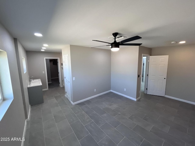 empty room featuring ceiling fan, recessed lighting, a sink, and baseboards