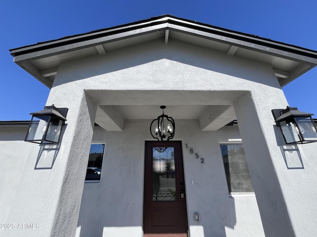 doorway to property featuring stucco siding