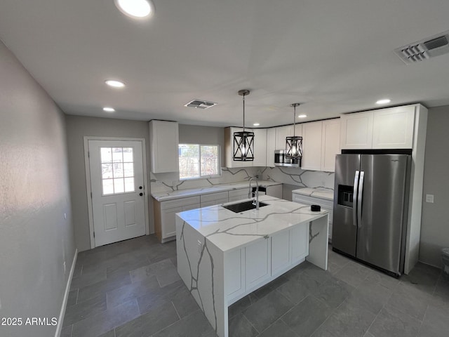 kitchen featuring visible vents, a center island with sink, appliances with stainless steel finishes, and white cabinets