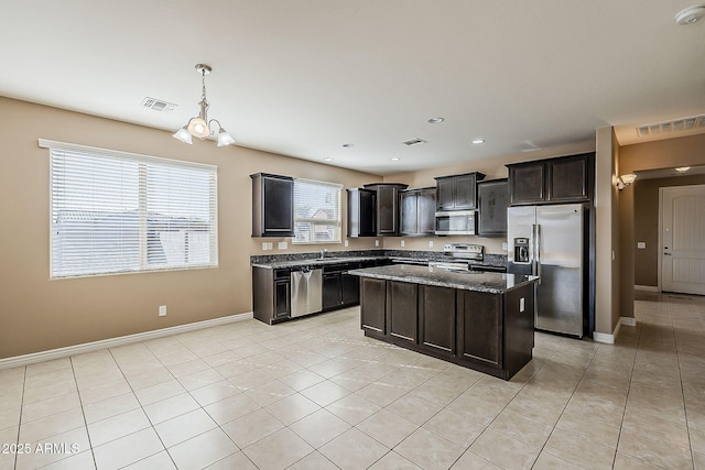 kitchen featuring dark stone countertops, visible vents, appliances with stainless steel finishes, and a sink