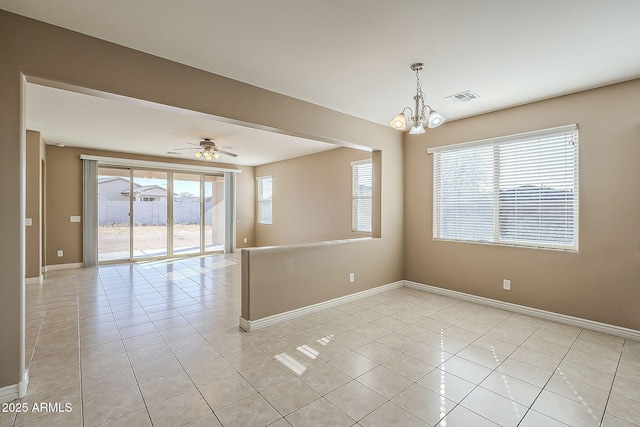 unfurnished room featuring baseboards, ceiling fan with notable chandelier, visible vents, and light tile patterned flooring