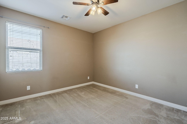 unfurnished room with carpet floors, baseboards, visible vents, and a ceiling fan