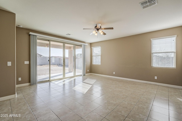 empty room featuring light tile patterned floors, visible vents, and a healthy amount of sunlight