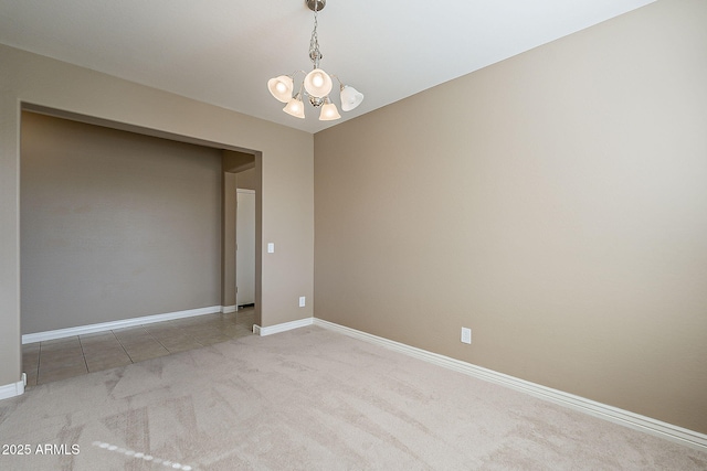 tiled spare room with carpet floors, an inviting chandelier, and baseboards