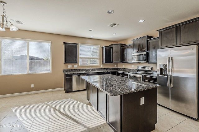 kitchen with light tile patterned floors, visible vents, a kitchen island, and appliances with stainless steel finishes