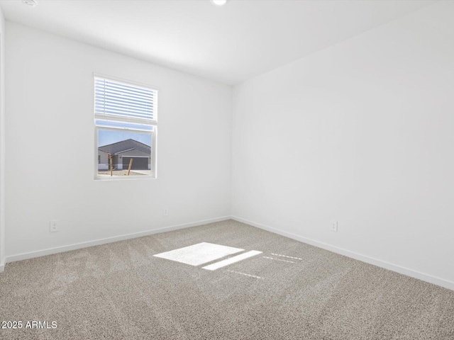 carpeted spare room with baseboards