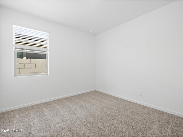 empty room featuring carpet floors and baseboards