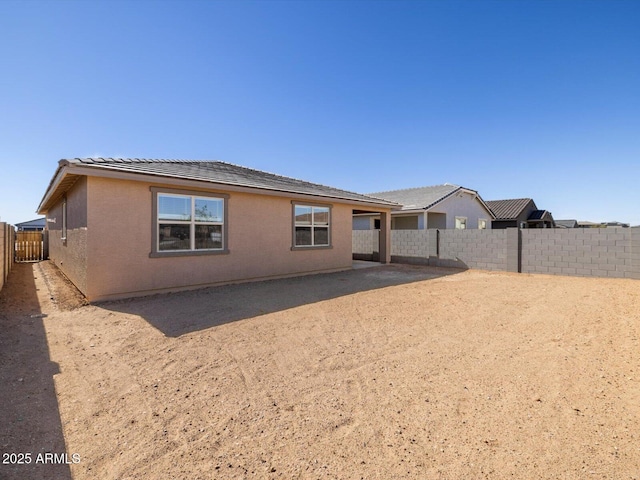 back of property featuring a fenced backyard and stucco siding