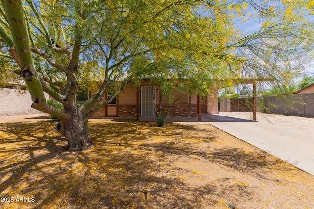 obstructed view of property with brick siding and fence