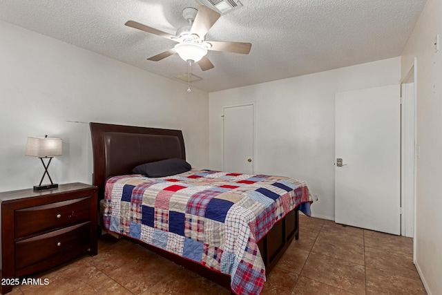 tiled bedroom with visible vents, a textured ceiling, and ceiling fan