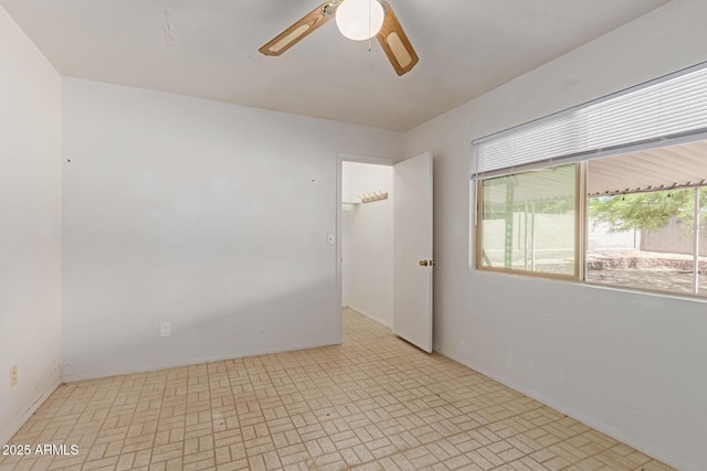 spare room featuring baseboards, a ceiling fan, and brick patterned floor