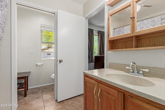 full bathroom with vanity, tile patterned flooring, toilet, baseboards, and ceiling fan
