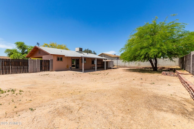 rear view of property featuring a patio and a fenced backyard