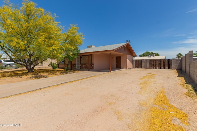 view of front of house featuring a gate, fence, and driveway