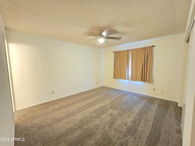 carpeted spare room featuring ceiling fan and a textured ceiling