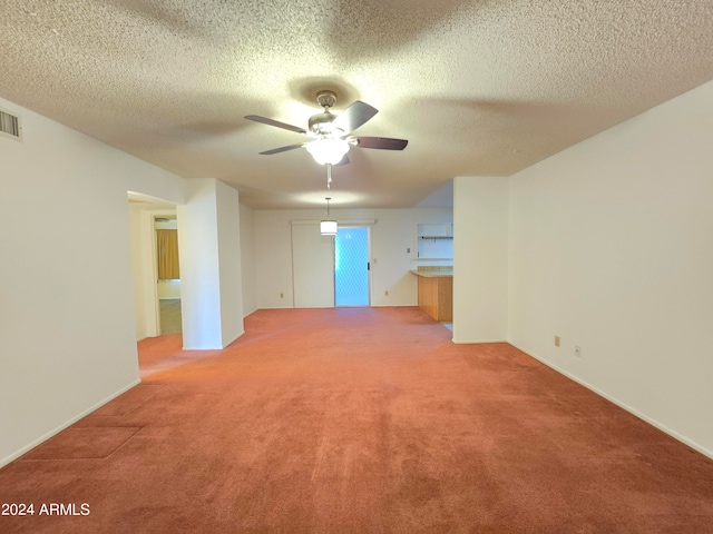 carpeted empty room featuring ceiling fan and a textured ceiling