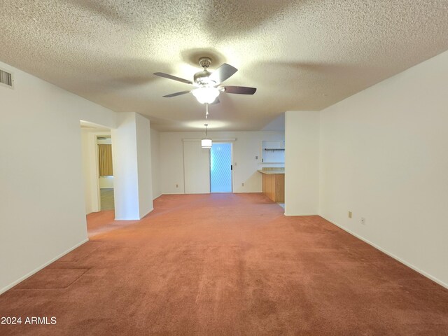 kitchen featuring kitchen peninsula, light colored carpet, sink, black appliances, and decorative light fixtures