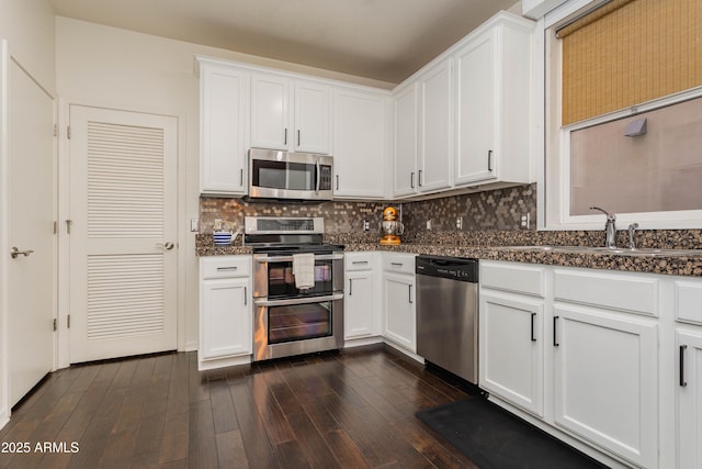706 E Washington St Unit 124, Phoenix, AZ 85034 - kitchen with appliances with stainless steel finishes, white cabinetry, dark wood-style flooring, and decorative backsplash